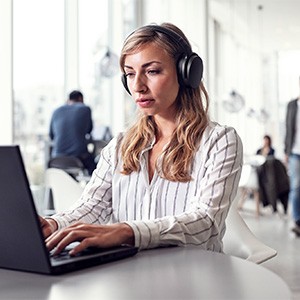 Young female office worker using a Sennheiser headset