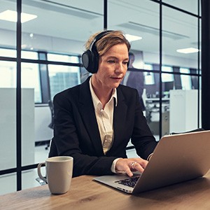 Experience Enhanced Concentration Female worker uses headphones whilst using a laptop