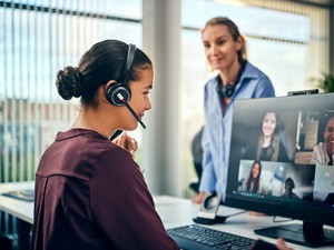 Optimise Talk With Audio Excellence Young female office worker using a Sennheiser headset