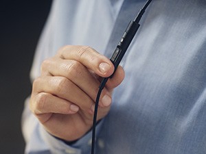 Handle Calls Seamlessly worker adjusts volume on headset