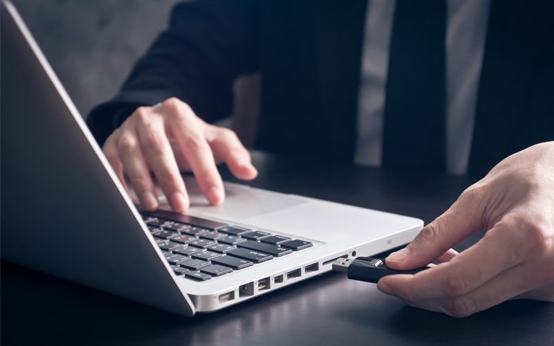 Secure USB to protect data Business man using USB drive in laptop device